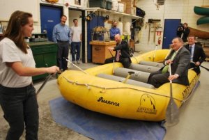 A student instructs John Nass, Education Commissioner Stephen Bowen and Gov. Paul LePage in a raft on a shoproom floor.