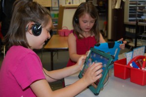 Sara Richard and Lauren Fletcher use their iPads to learn letters and to spell words.