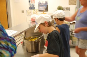 Brooklin students in grades 4 through 8 are on a rotating schedule to help cook Lori Boyce in the kitchen. Last Thursday, Colby Schneider served broccoli to students, and Lucas Torrey dished up corn.