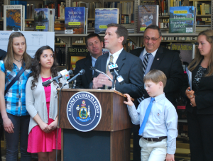 Education Commissioner Stephen Bowen explains A-F school report cards with Governor Paul R. LePage while students look on during press conference at the Maine State Library.