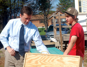 Eighth grader Ken Stump shows Commissioner Bowen a solar panel they created to heat the indoor greenhouse at Roberts Farm in Norway.