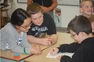 Fifth graders (from left) Liana Shaw, Blake Jeffries and Colby Brown work together on Final Jeopardy question about greek and latin root words.