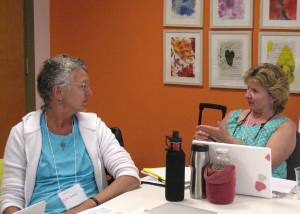 Visual art teachers Debi Lynne Baker (left) and Jane Snider discuss proficiency and standards at the MAAI summer institute at Maine College of Art.