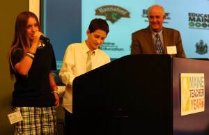 Students Adie Hughes and Chase Hathorn from the Weatherbee School in Hampden present their teacher,  Susan Carpenter O'Brien, a semi-finalist for the 2014 Teacher of the Year, at a banquet in Portland last Friday as Acting Education Commissioner Jim Rier looks on