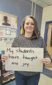 An educator from Calais Elementary school holding up a poster that says "my students have taught me joy"
