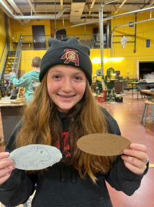 Lyla Picard, 8th grader, shows off her drawing that was then imprinted onto cardboard using the Glowforge printer.