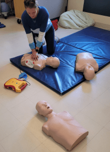 A nurse practices CPR on a CPR manikin.
