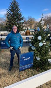 Joshua Chard, East End Community School Teacher and 2024 Maine Teacher of the Year, standing next to Maine's national Christmas tree.