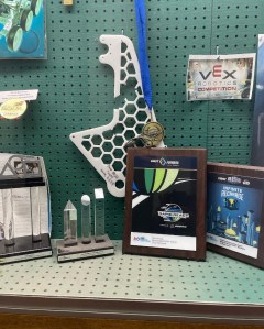 LRTC 8023’s two awards in a display case at their school.  Two events, two awards, including an Alliance win, is quite the feat.  The broken piece was sent with love from Team 6324 with the inscription “Ouch!”