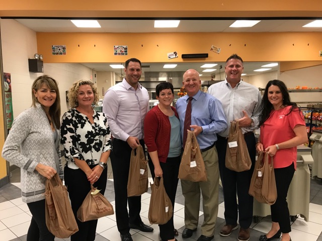 School Administrators holding shopping bags of food.