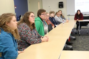 students sitting in a meeting listening