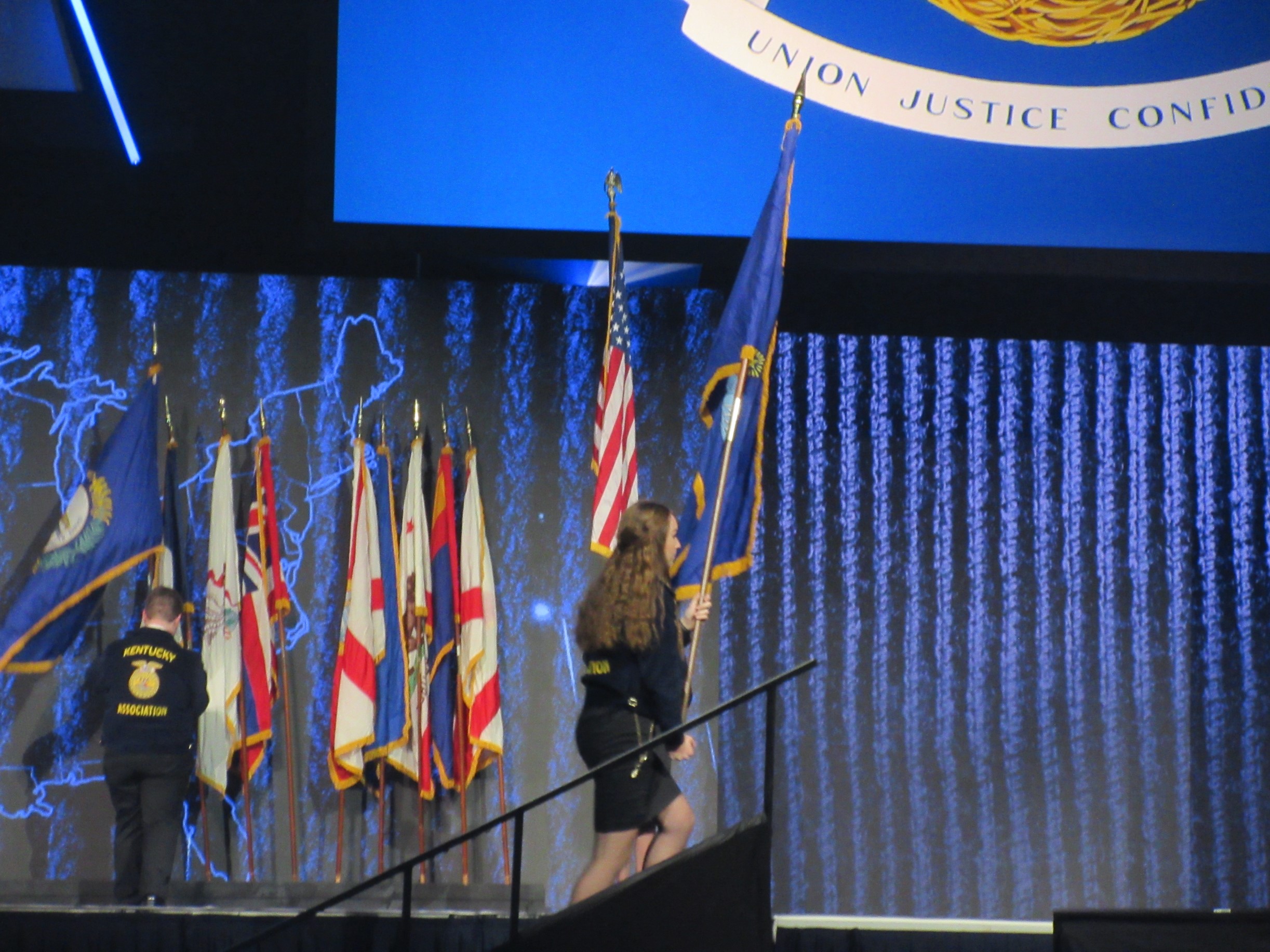 Maine FFA State Secretary-Treasurer Ava Cameron presents the Maine Flag at the Opening Session.