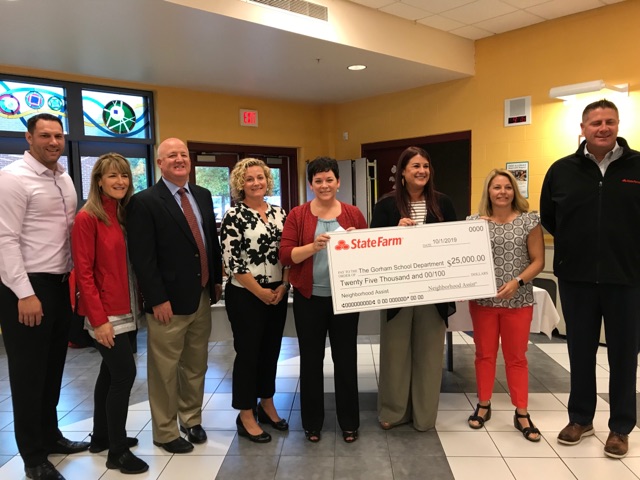 School administrators standing holding a large check from State Farm