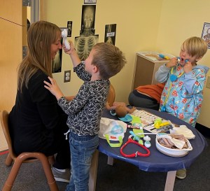 Maine DOE Contract Grant Specialist, Jane Kirsling, gets her temperature checked in the dramatic play area during a visit this fall.