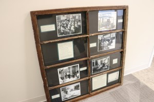 Black and white photos taken in unorganized territories, now on display in an old window frame from an EUT school at the Maine DOE.