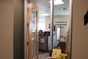 The entrance way to the office of the Education in Unorganized Territories (EUT) where EUT staff member Cathy Severance can be seen sitting at her desk.