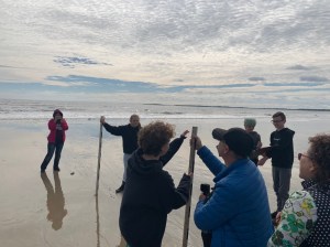 students and educators on the beach by the ocean