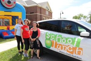 Sarah Perkins and Catherine Hoffmann, from the Maine Dairy & Nutrition Council pose Adriane Ackroyd from the Maine Department of Education's Child Nutrition Team.