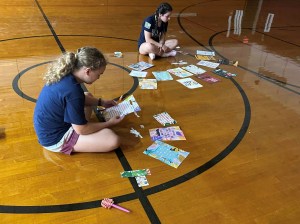 students sitting on gym floo4 working on a project
