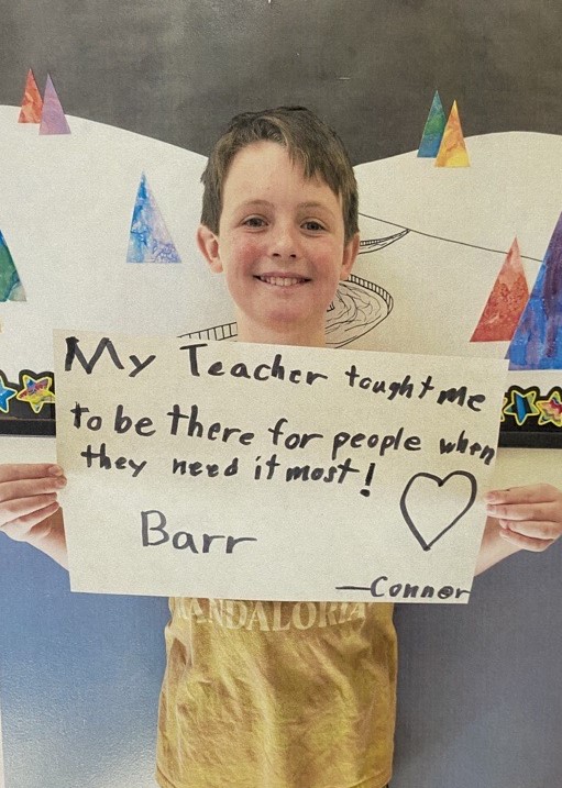 A Calais Elementary student holds up a sign that says "my teachers taught me to be kind to other and how to be myself."