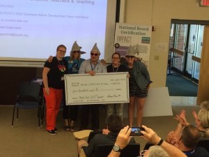 Group picture of educators holding a big check