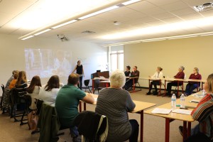 presenter talking to a round table room of educators.