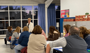 women standing in front of a group of people sitting and listening