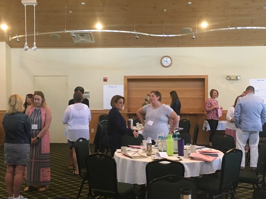 Teachers standing around talking to each other at a training event