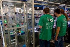 Members of B.E.R.T. try to get their robot up onto a higher bar at the conclusion of a match
