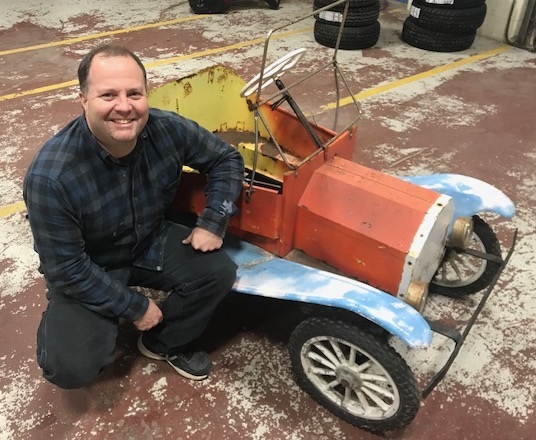 Patrick Penley crouches next to his repaired clown car that he brought back to life thanks to the help of a Lewiston Adult Education class