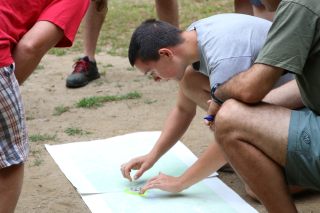 A student shows the class how to locate their position on the map
