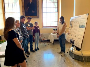 students standing with poster presenting