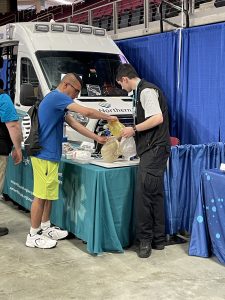A Northern Light employee assists a young person in a CPR demonstration.