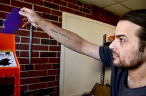 Luis Jones-Rodriguez, the MDIRSS/AOS #91 IT Lead, inserts discarded 3D printed items into the grinder to prepare to convert it into printer filament.