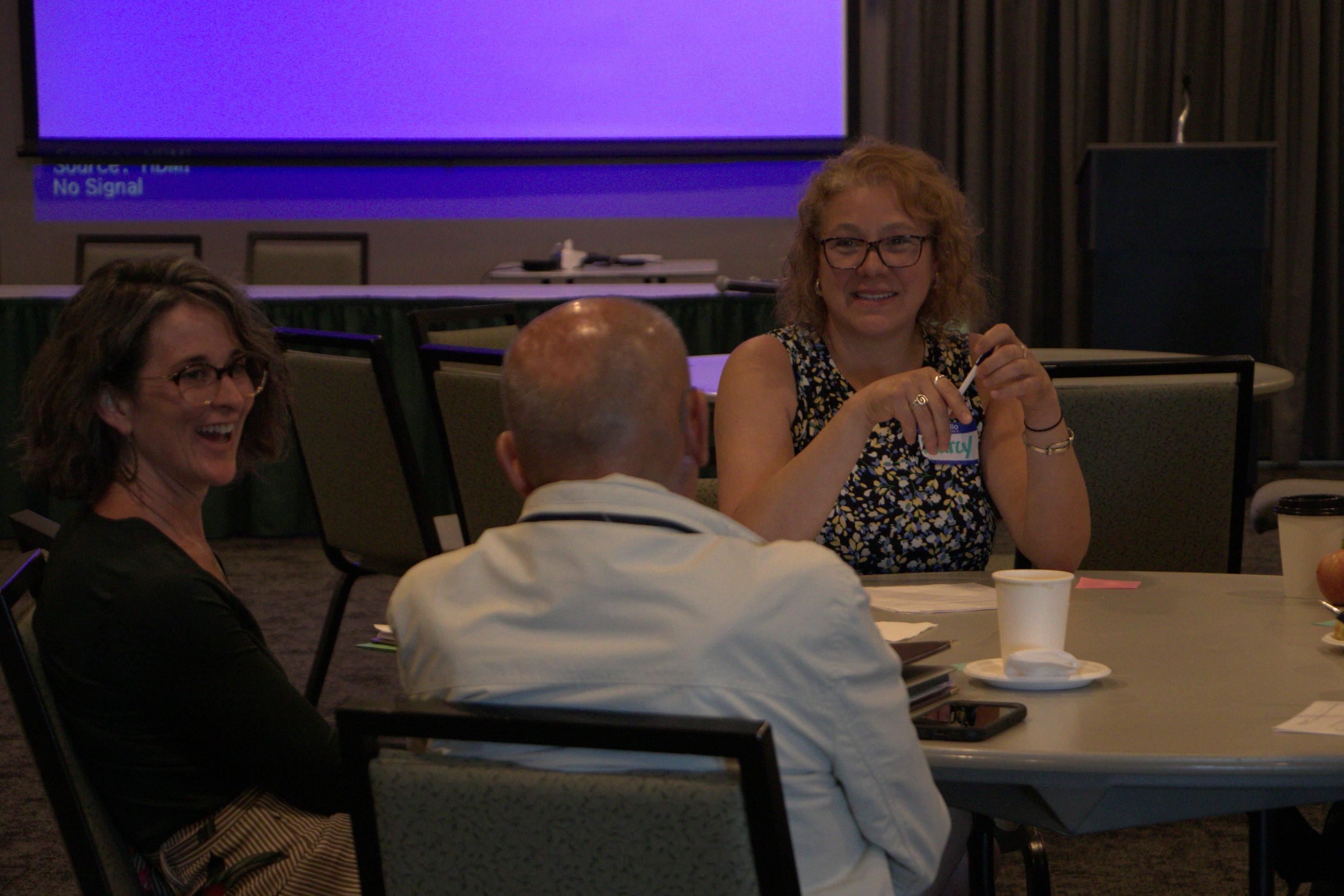 Summit participants share reflections and ideas during post-session table conversations.