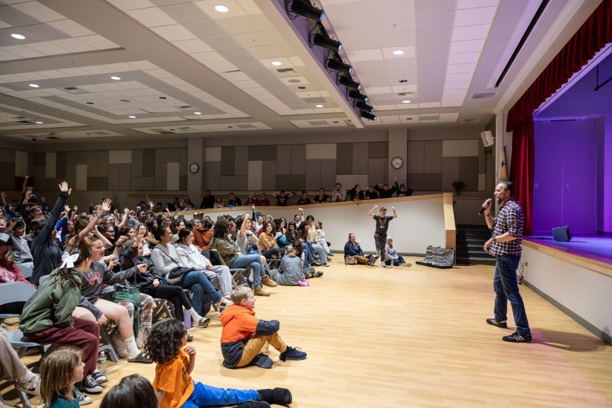 Room full of students in an audience.