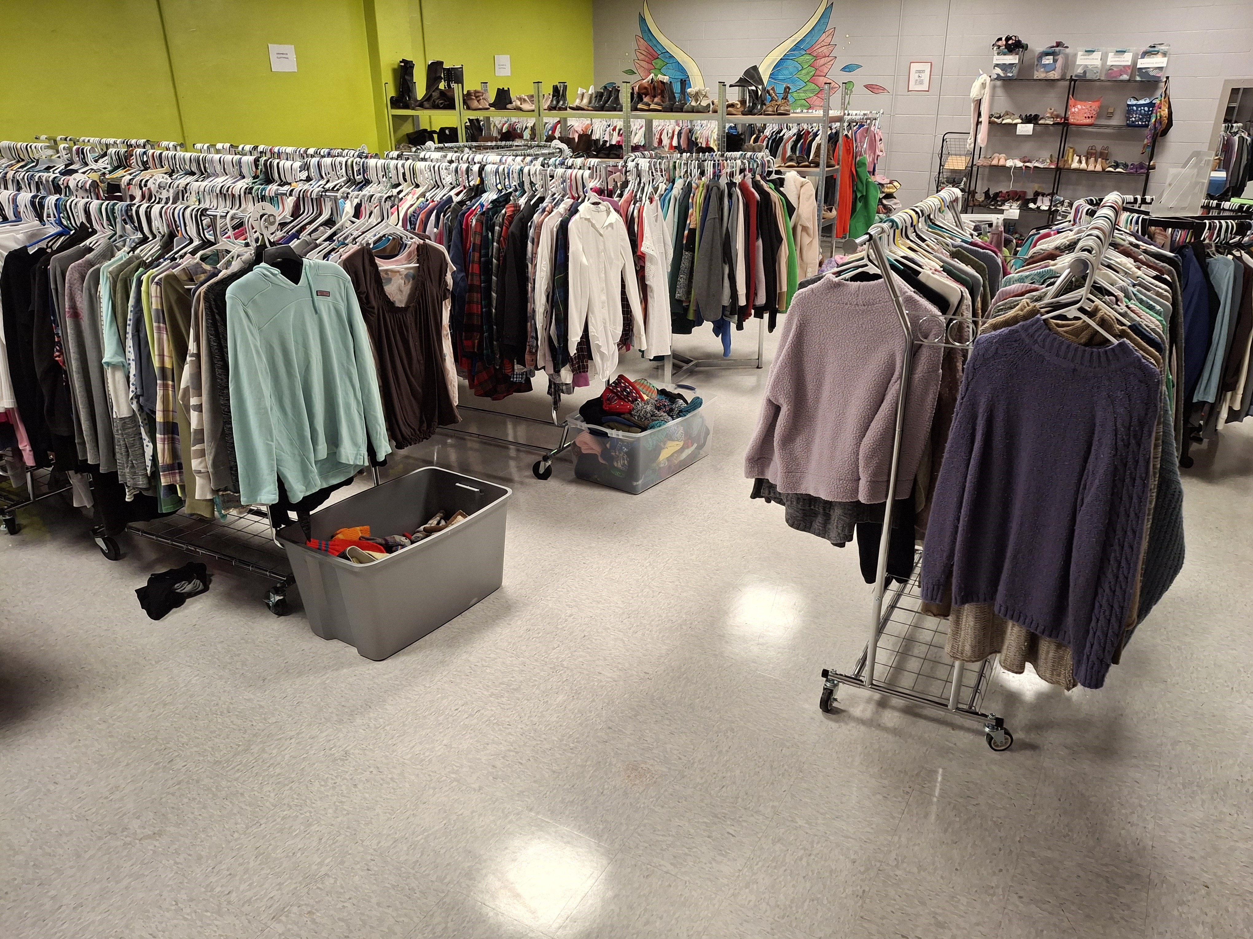 a bunch of racks with clothes on hangers