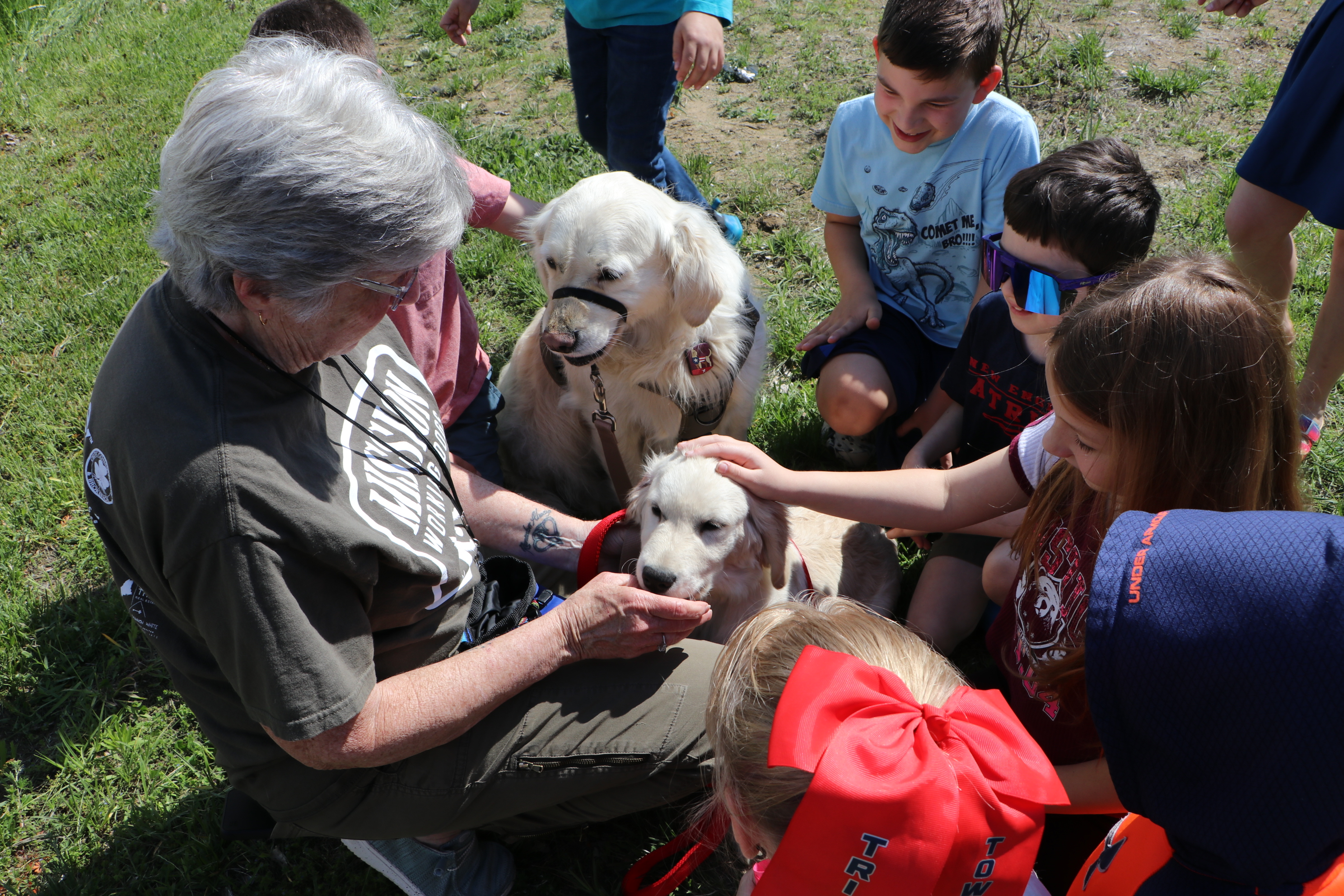 Students visit with therapy dogs with the help of dog handler Moria Case.