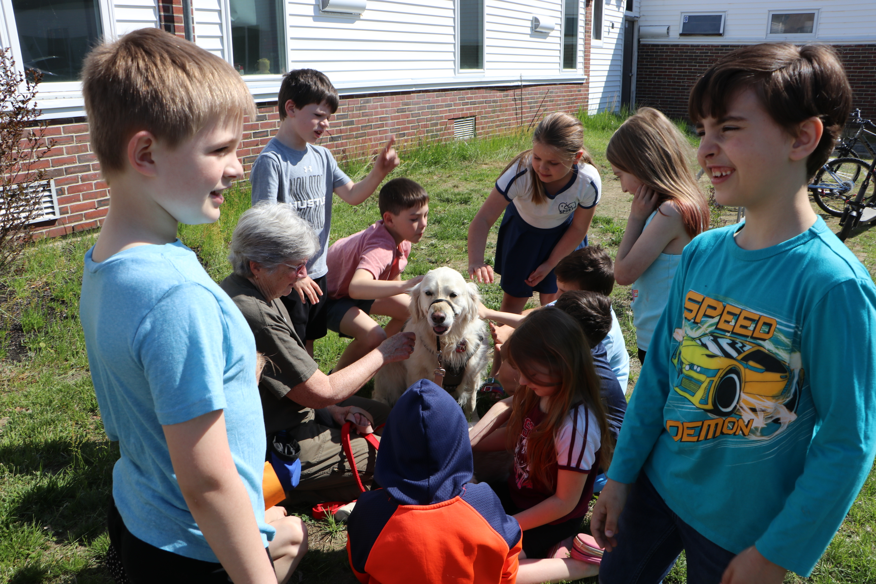 Students visit with therapy dogs with the help of dog handler Moria Case.