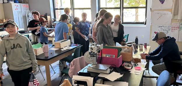 A sample paycheck and Sheepscot students in line to deposit their weekly paychecks.