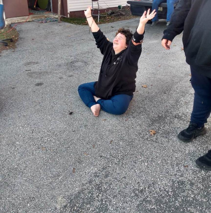 A REACH School student celebrates after learning how to start a primitive fire in ecology and igniting a spark for the first time.