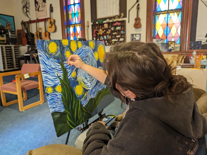 A REACH School student paints her version of The Starry Night.