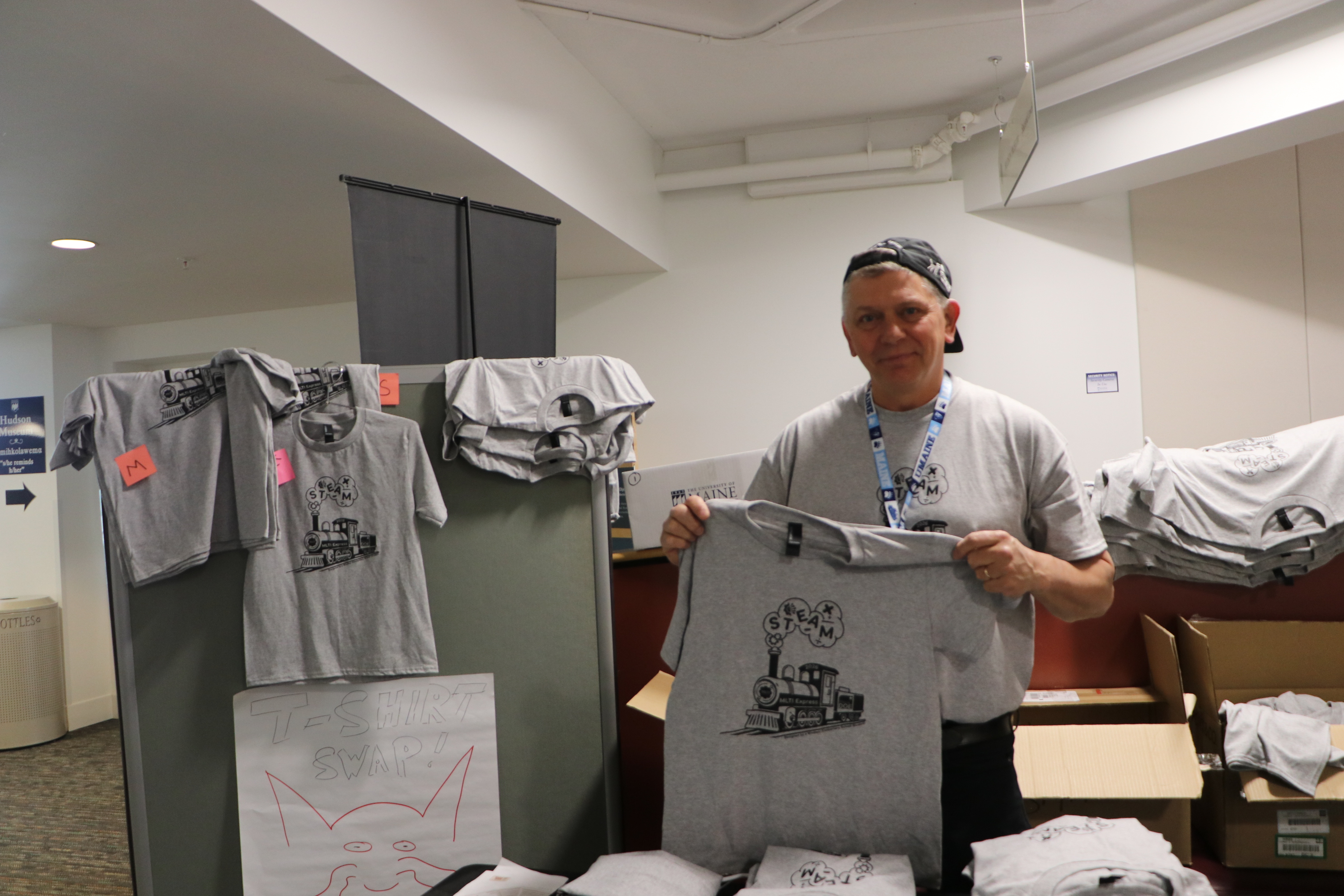 Maine DOE Learning Through Technology team member Jim Chasse holds up the conference t-shirt.