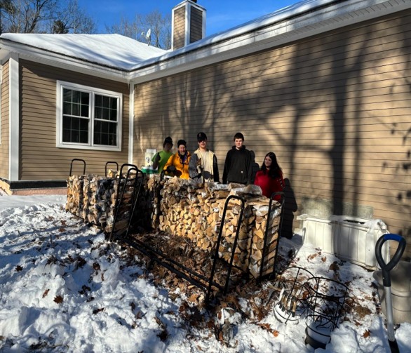 Katahdin Program students stack wood for a local senior citizen.